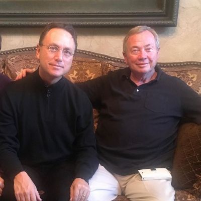 They are both wearing black while sitting on a couch.